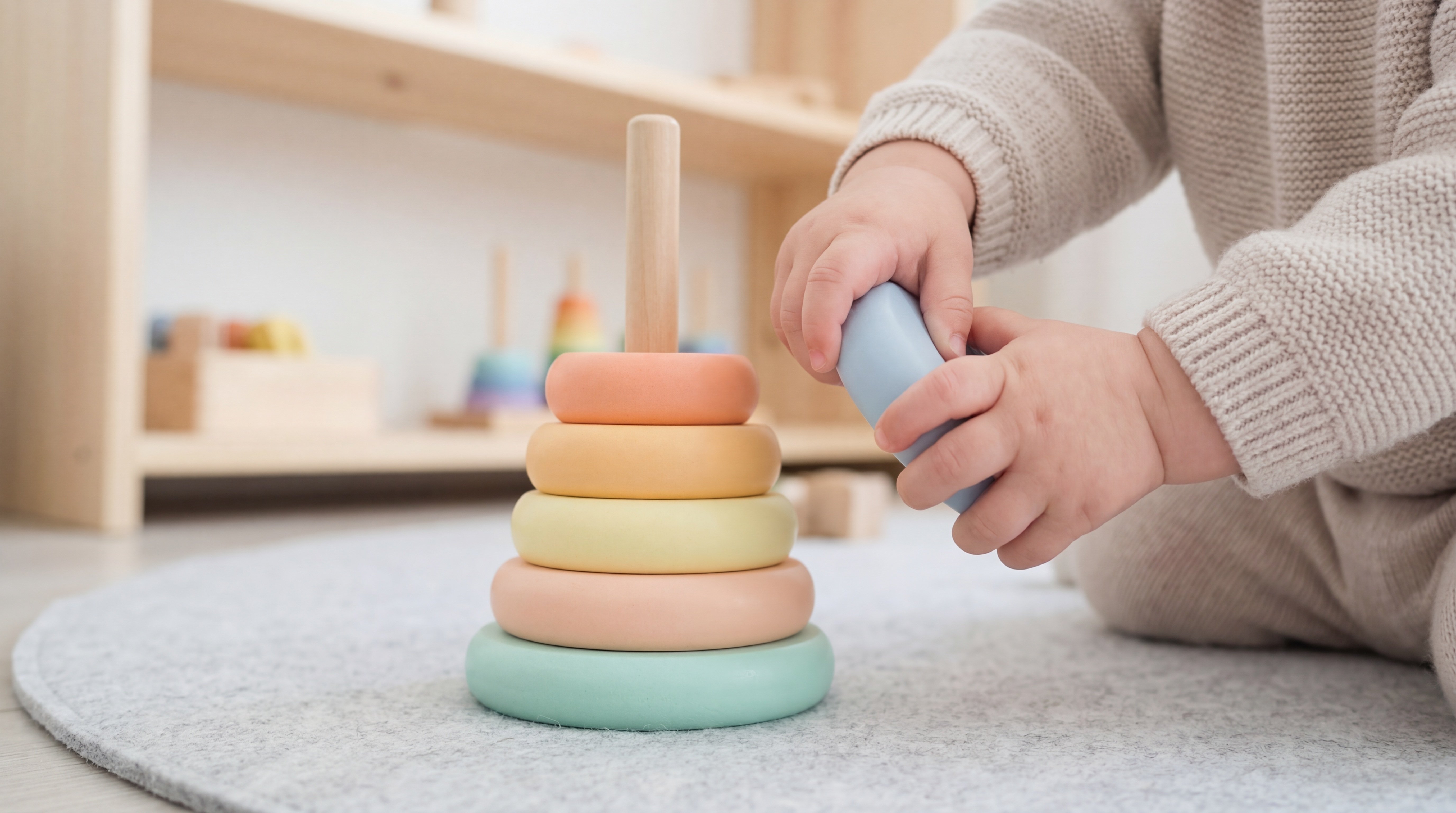 Kleine Hände stapeln Ringe