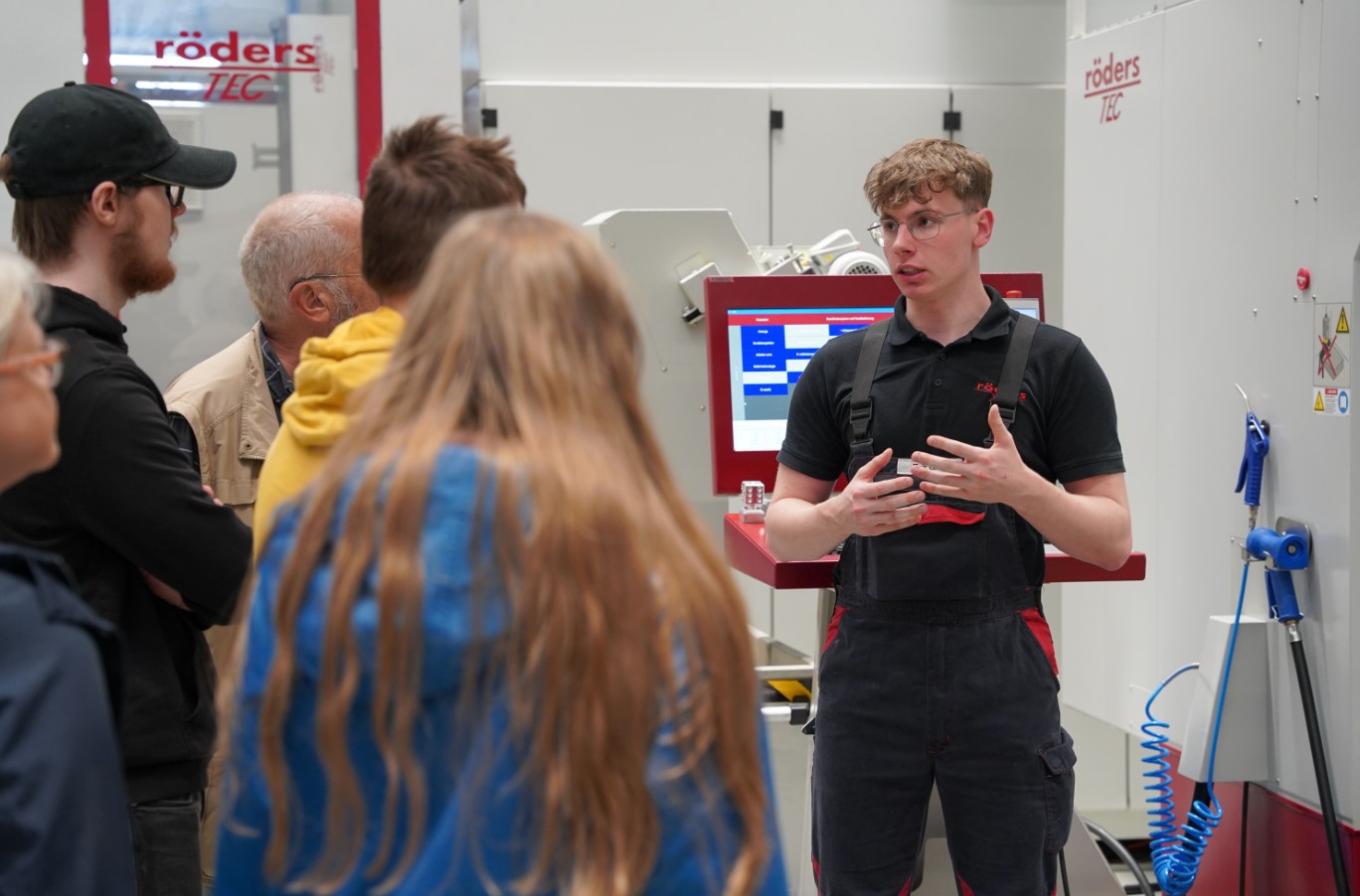 Ein Mitarbeiter von Röders Tec infomiert fünf andere Personen über die Aufgaben des Unternehmens.