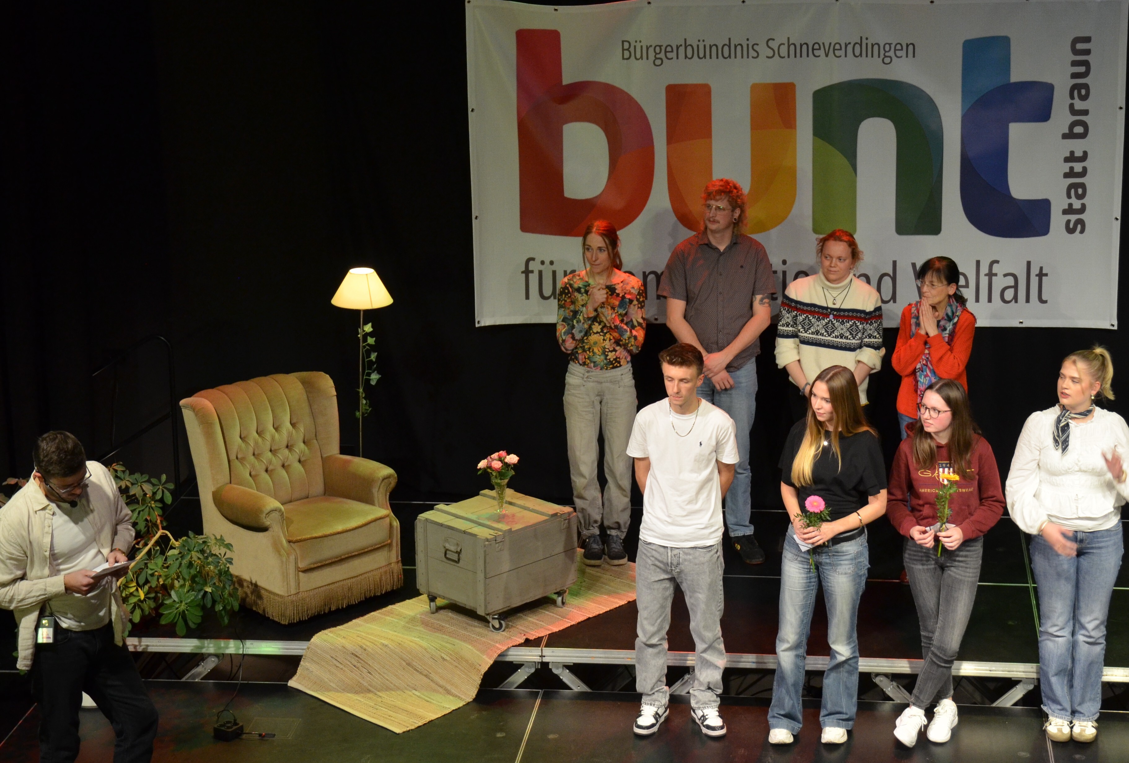 Personen stehen auf der Bund, eine Person sitzt.