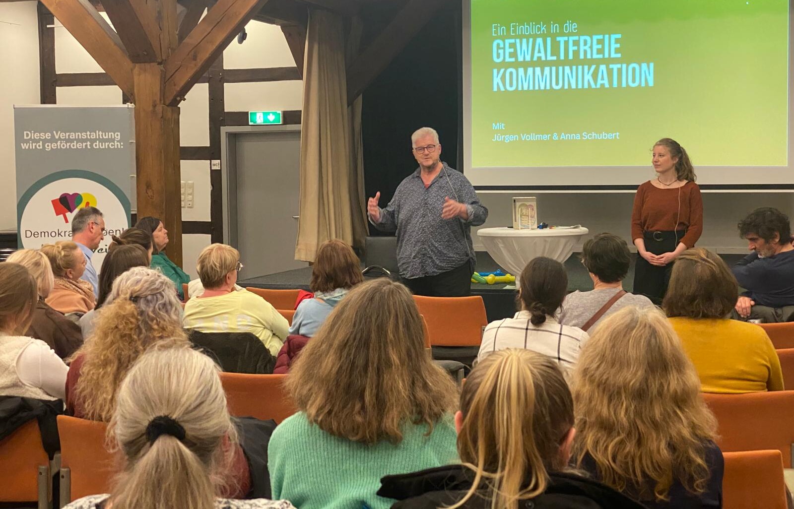 Personen hören dem Vortrag zu.