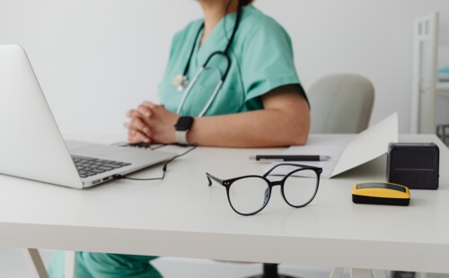 Eine Ärztin sitzt an einem Schreibtisch.