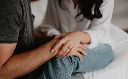 Angehörige nehmen Anteil und haben ihre Hand auf das Bein einer Person gelegt. Angehörige nehmen Anteil und haben ihre Hand auf das Bein einer Person gelegt.