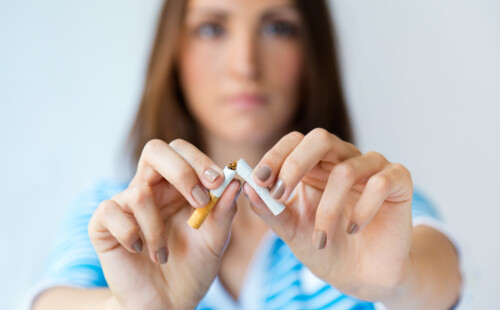 Eine Person zerbricht eine Zigarette. Eine Person zerbricht eine Zigarette.