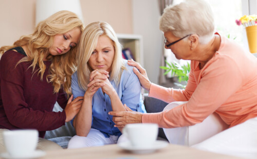 Drei Frauen unterschiedlichem Älters sitzen zusammen und unterhalten sich. 