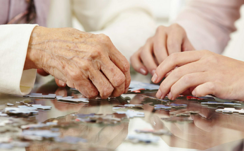 Personen sind beim Puzzeln.