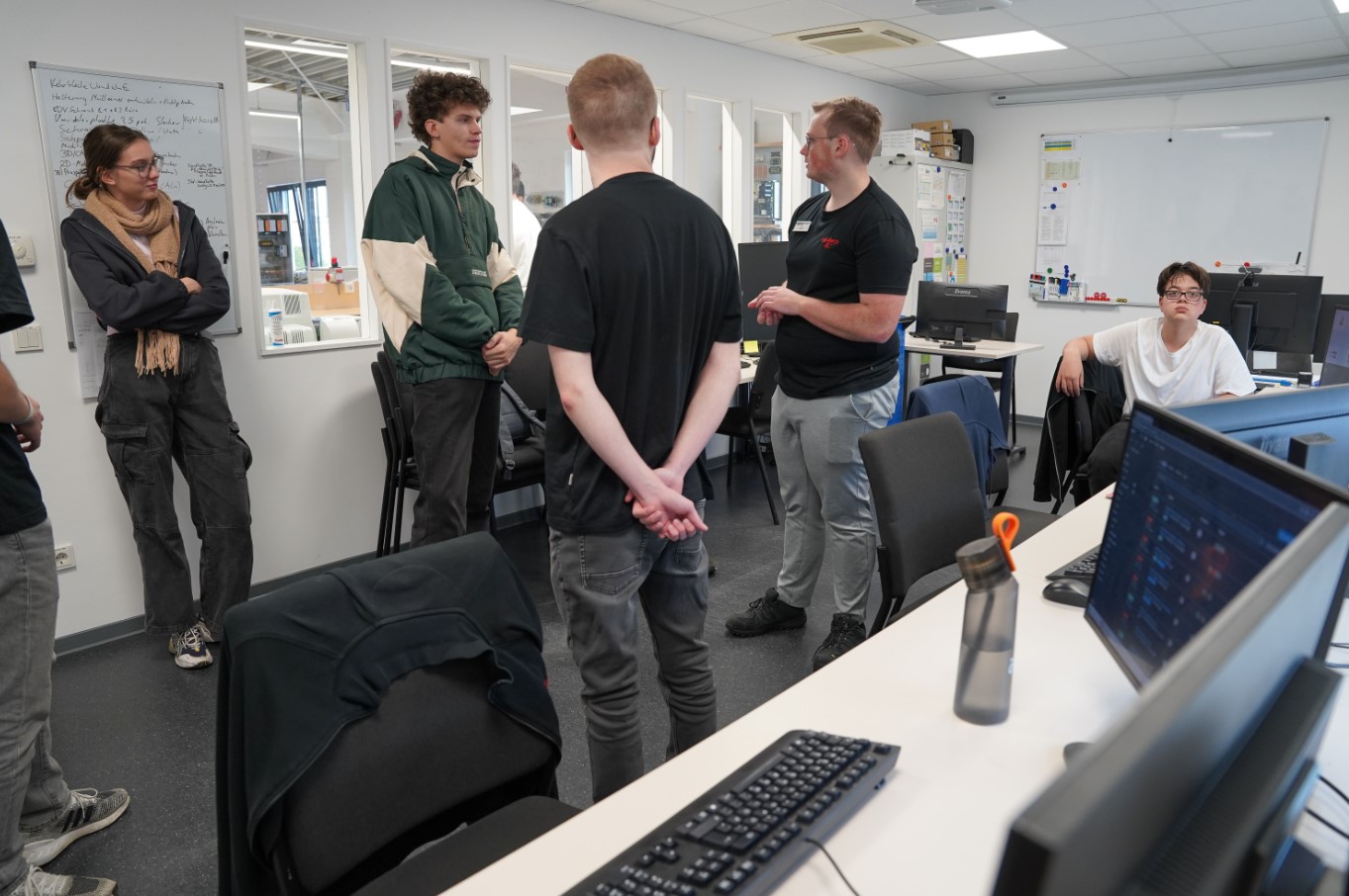 In einem Büro mit mehreren Computern informieren Mitarbeiter von Röders Tec andere Personen über die Aufgaben im Betrieb.