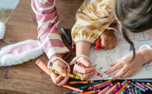 Mädchen malen mit Wachsmalstiften
