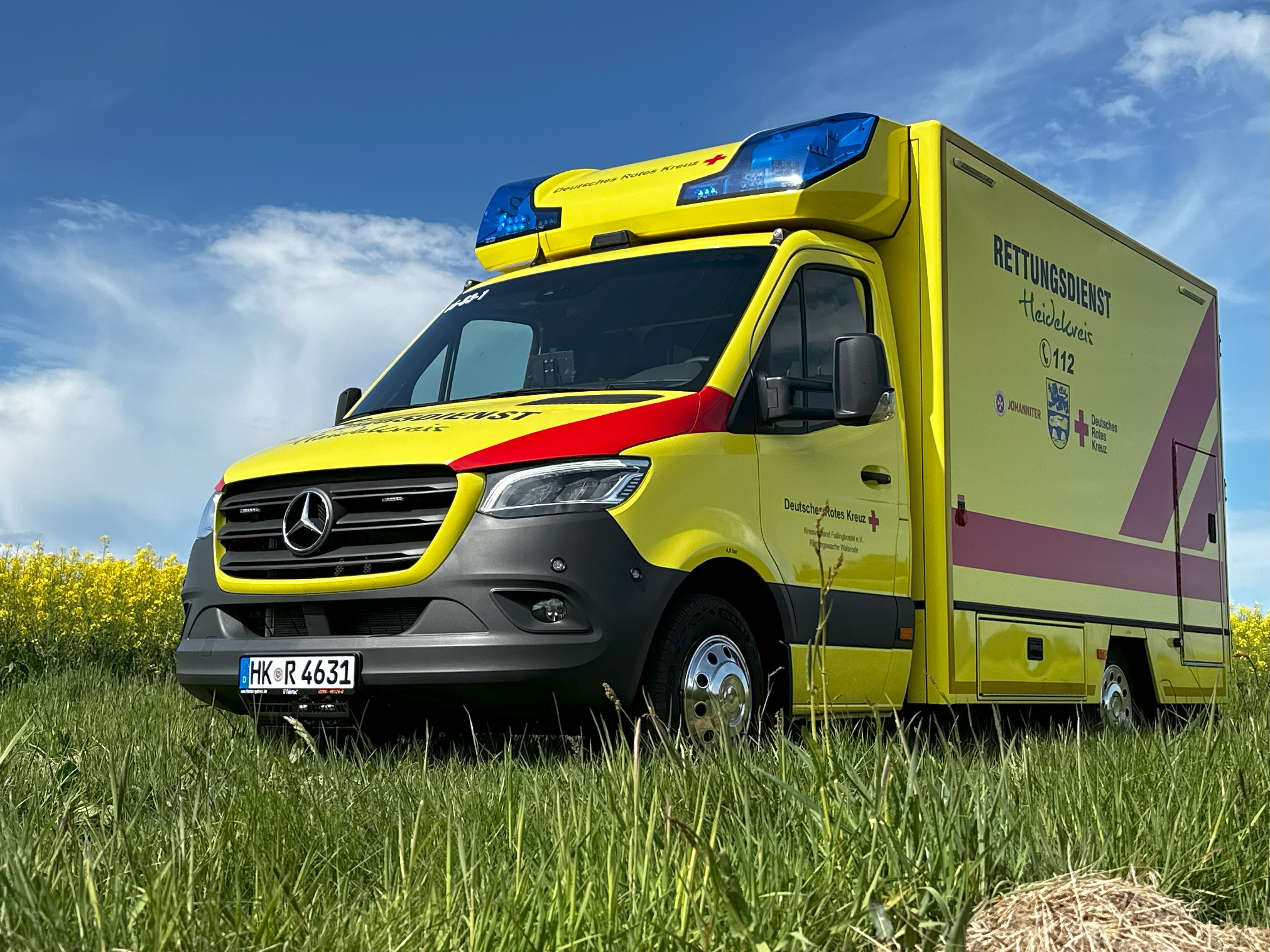 Ein gelbes Rettungsfahrzeug steht auf einer Wiese im Heidekreis